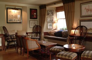 A traditional room with wooden furniture, a patterned rug, and framed pictures on the walls. - The Royal Hotel (Crieff)