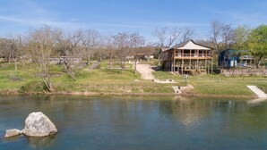 A lakeside building with a dock, surrounded by trees and a clear sky.
