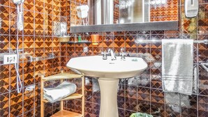 Une salle de bain équipée d’un lavabo, d’un miroir et d’un porte-serviettes.