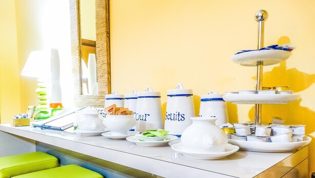Un buffet de petit-déjeuner avec divers aliments et récipients, notamment un présentoir à trois niveaux garni de viennoiseries.
