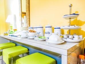A breakfast buffet setup with various food items and containers, including a three-tiered stand with pastries. - B&B Morelli 1 (Rome)