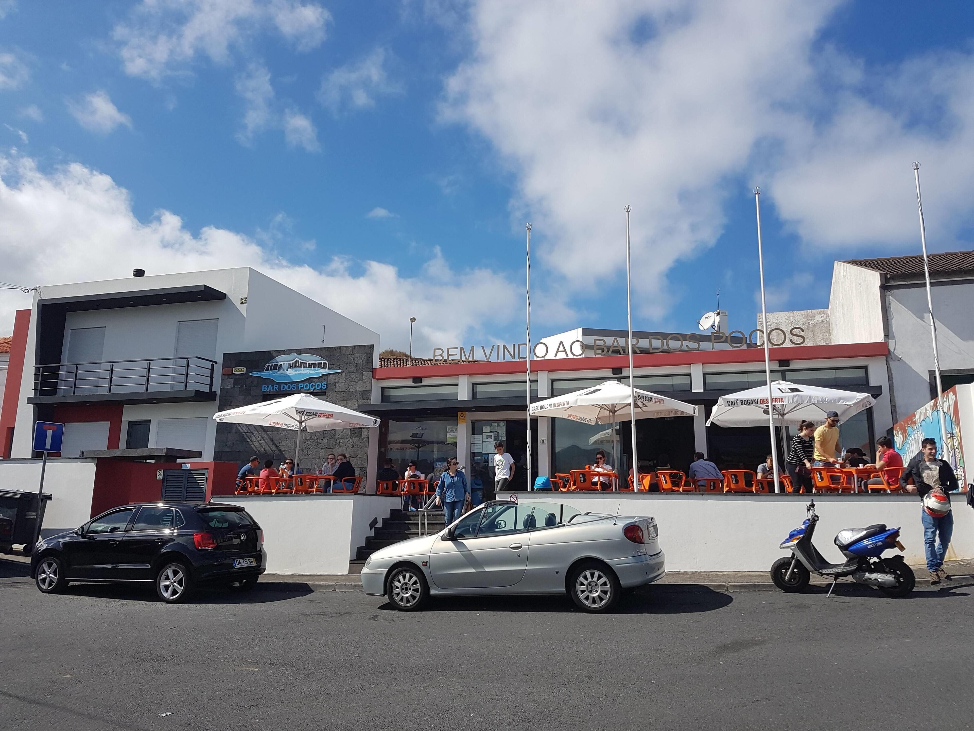 Um edifício com área externa para sentar e um letreiro que diz 'Café Bogão'.