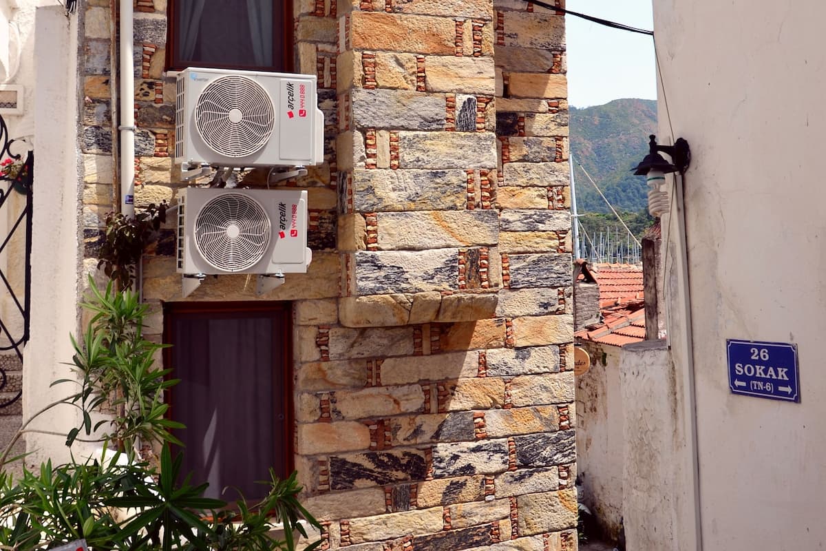 Ein Gebäude aus Stein mit zwei an der Außenwand angebrachten Klimaanlagen.