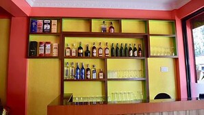Un espace bar avec des étagères remplies de bouteilles d’alcool et de verres.