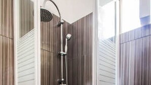 A shower with a glass door, a toilet, and a showerhead. - Wavedance Accommodation (Salamis)