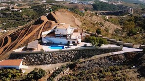 A hillside villa with a swimming pool, stone walls, and a view of the surrounding landscape. - Villa El Palomar Azul (Los Puertas)