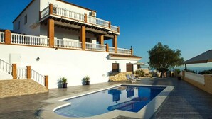 A two-story building with a swimming pool, outdoor seating, and a view of the sea. - Villa El Palomar Azul (Los Puertas)