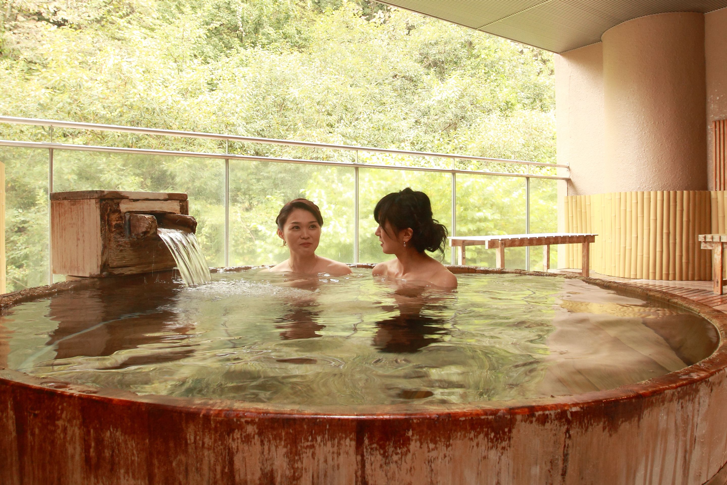 A hot spring with a wooden structure and a glass barrier.