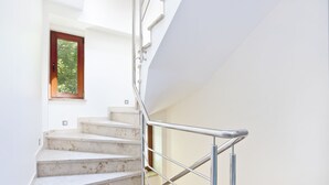 Eine Treppe mit Metallgeländer und einem Holzfenster.