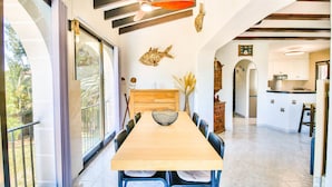 A dining area with a wooden table, chairs, and a decorative fish wall art piece. - Villa with pool and garden Don Quijote AM 6 Pers Denia (Denia)