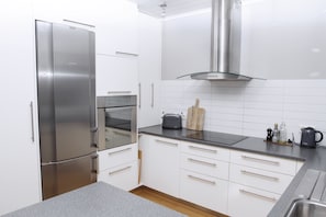 Apartamento, 3 quartos | Cozinha privada | Geladeira grande, micro-ondas, fogão, cooktop