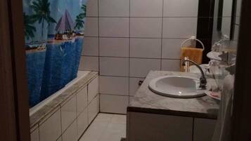 Une salle de bain avec une baignoire, un lavabo et un miroir.