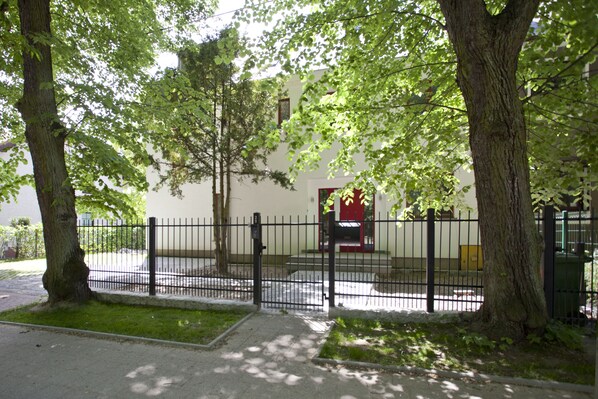Stroll through the tranquil grounds, surrounded by mature trees and a well-manicured lawn, to the entrance of this serene building.