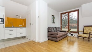 Un salon moderne avec un canapé, un fauteuil et une petite table sur laquelle est posé un vase.