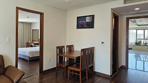 A hotel room with a dining area, a bed, a desk, and a view of the city. - Tamarind Hotel Da Nang (Da Nang)