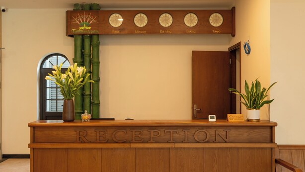 A reception desk with clocks displaying times for Paris, Moscow, Da Nang, Beijing, and Tokyo. - Tamarind Hotel Da Nang (Da Nang)