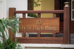A wooden sign with the number 83 and the name 'Trần Bach Dương' indicating a property or location. - Tamarind Hotel Da Nang (Da Nang)