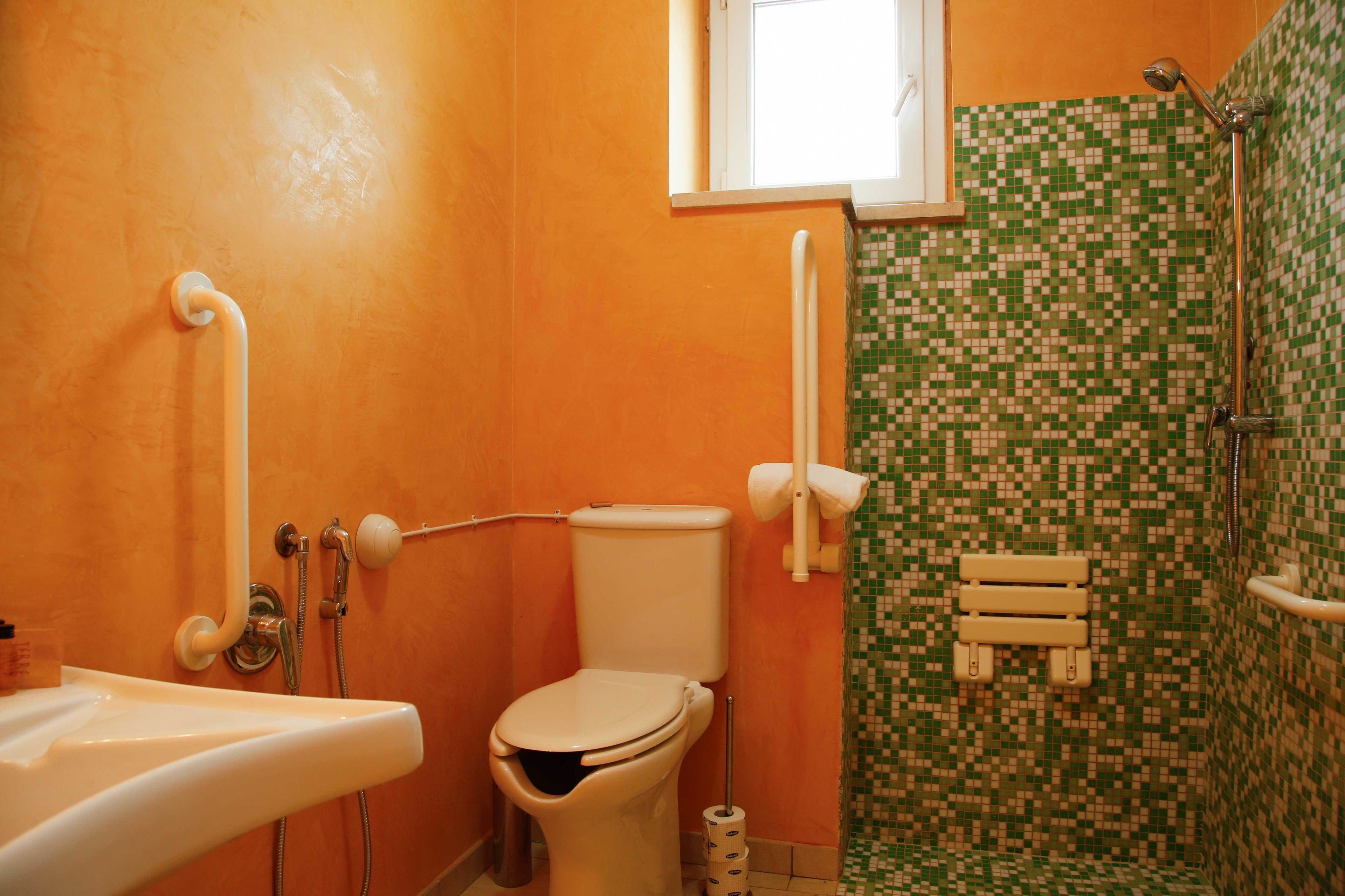 Een badkamer met toilet, wastafel en douche.