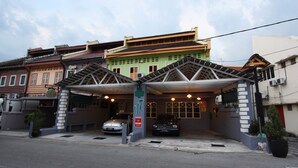 A multi-story building with a covered parking area. - Shamrock Guest House II (Ipoh)