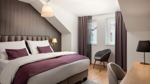 Une chambre à coucher moderne avec un grand lit, un bureau et une chaise.