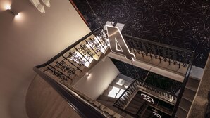 Un escalier moderne, agrémenté d’un grand panneau indiquant le chiffre « 4 », doté d’un revêtement de sol en marbre et d’une rampe en métal.