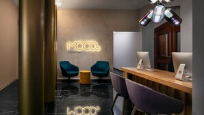 Un intérieur moderne avec un comptoir d’accueil, des chaises de couleur turquoise et un sol en marbre.
