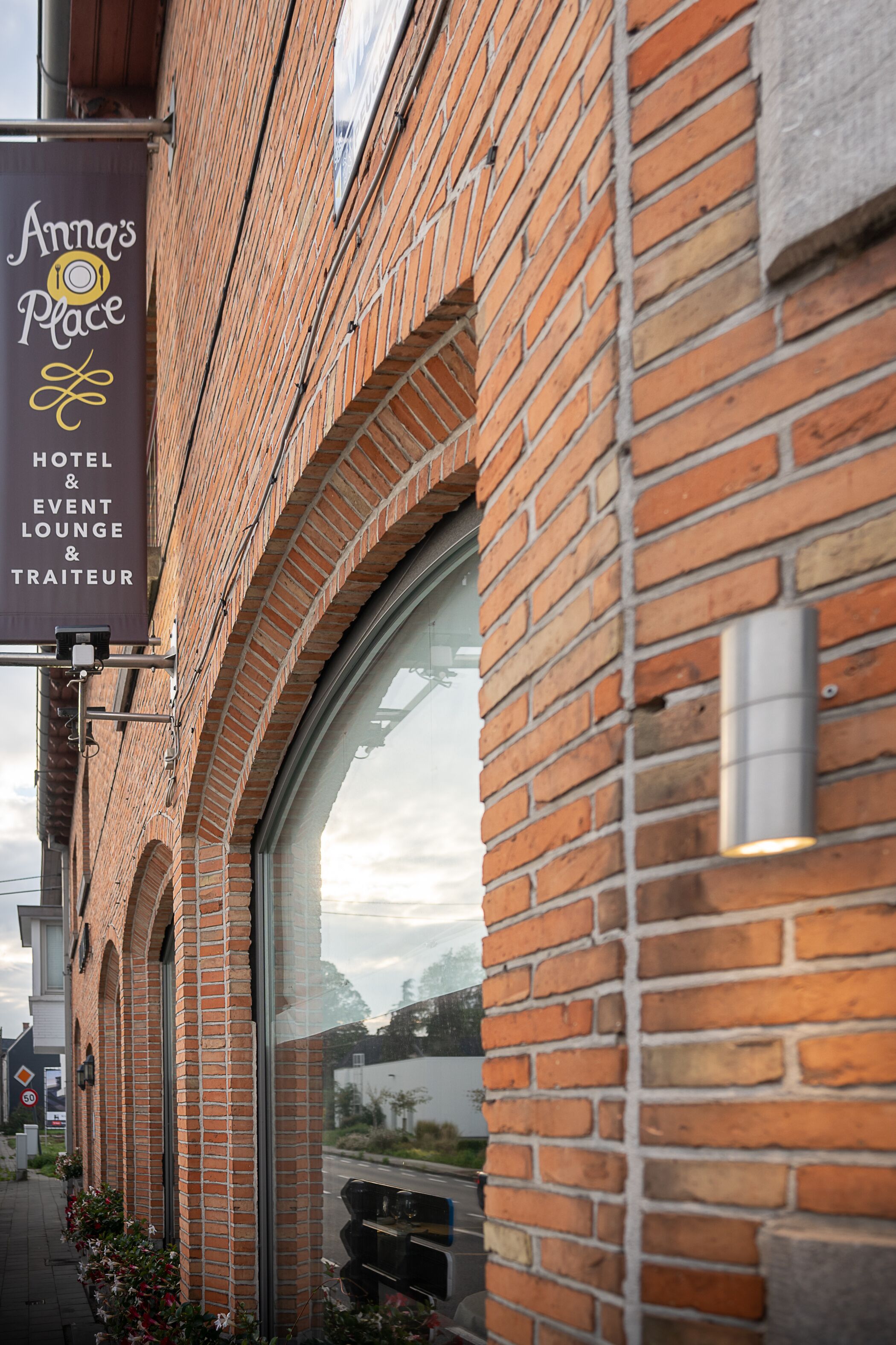 A brick building with a sign for "Anna's Place Hotel & Event Lounge & Traiteur."