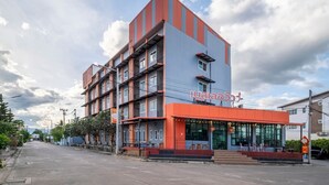 Un edificio de varios pisos con un diseño moderno, que destaca por su fachada naranja y gris.