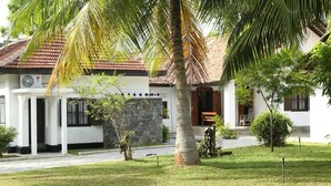 Un bâtiment blanc avec un mur en pierre et un toit recouvert de tuiles.
