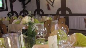 Una mesa lista para comer, con un menú, copas de vino y una jarra.