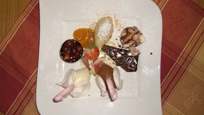 Un plato cuadrado con diversos alimentos, como carne, queso y verduras.