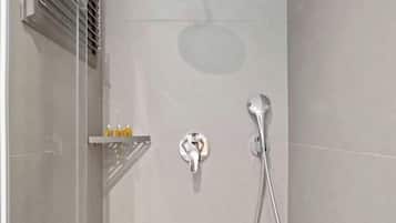 A modern shower with a handheld showerhead and a wall-mounted faucet.