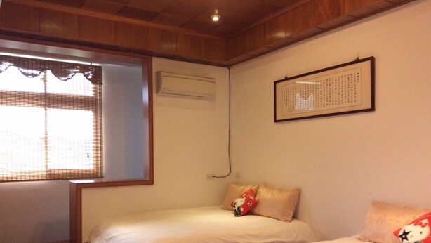 A room with two beds, a window with blinds, an air conditioning unit, and a framed picture on the wall. - Yuan Zhong Yuan B&B (Luye)