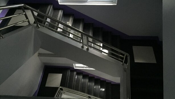 A staircase with metal railings and a skylight above.