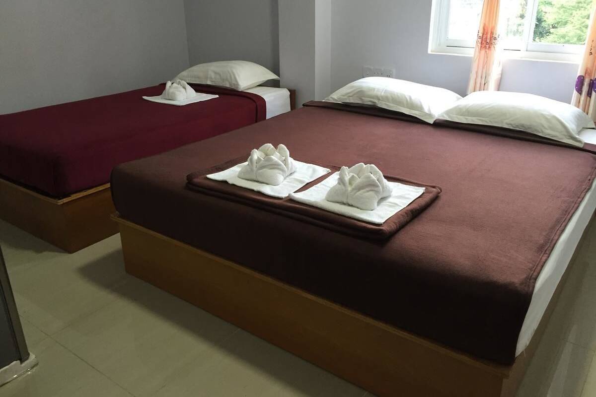 Une chambre d’hôtel avec deux lits, chacun étant équipé d’oreillers et de serviettes blancs.
