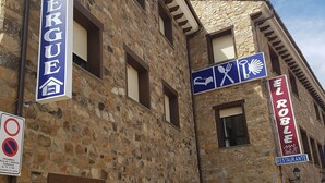 Um edifício de pedra com vários sinais, incluindo um para restaurante e outro para hotel.