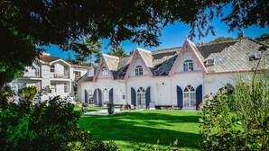 A large, white building with multiple windows and a well-maintained lawn. - Woodlands Hotel (Sidmouth)