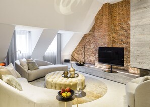 A modern living room with a brick fireplace, a sofa set, and a flat-screen TV. - de Gulde Schoen (Antwerp)