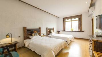Un dormitorio con dos camas, un escritorio, una silla y una ventana con cortinas.