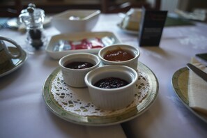 A table with three small bowls of jam on a lace doily. - Fir Tree B&B at Galvelbeg House (Crieff)