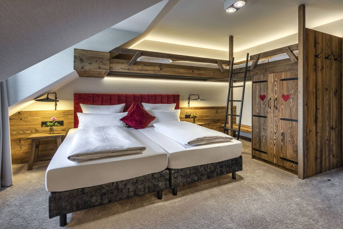 Camera da letto con letto a soppalco, testiera in legno, comodini e un armadio con decorazioni a forma di cuore.