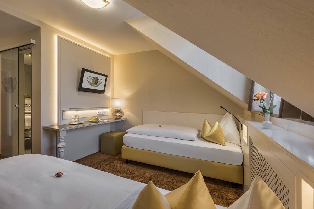 Una camera d'albergo con un letto, una scrivania, una sedia e un piccolo tavolino.