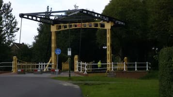 A pedestrian bridge with a metal structure and a blue sign indicating a bicycle path.