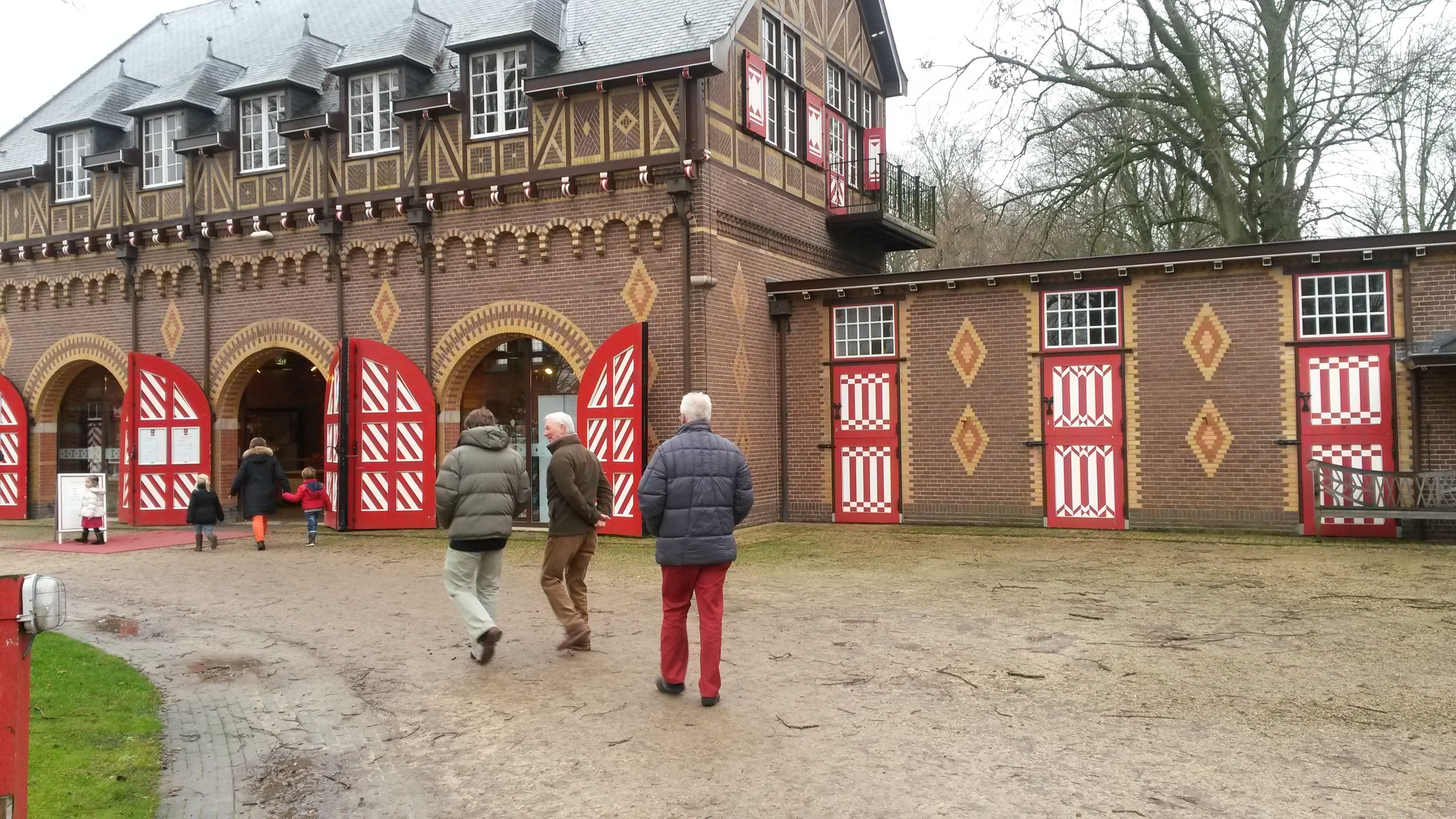Un bâtiment historique doté d’arcades et de portes aux motifs rouges et blancs.