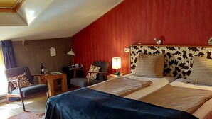 A hotel room with a large bed, a desk, a chair, and a lamp. - Boerderij Hazenveld (Kockengen)