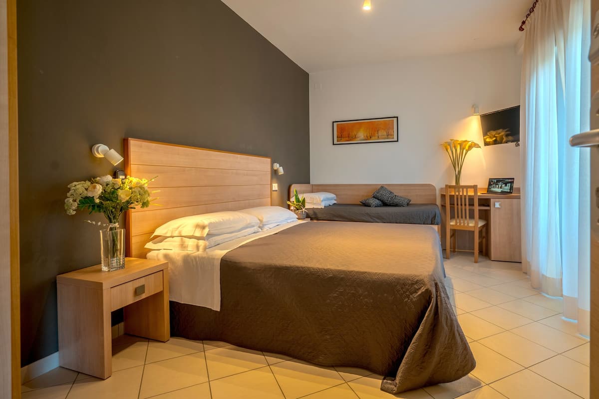 Habitación triple superior, vista parcial al mar, en esquina | Escritorio, wifi gratis y ropa de cama