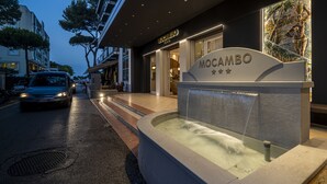 A modern hotel entrance with a water feature and a sign reading "MOCAMBO". - Hotel Mocambo (Riccione)