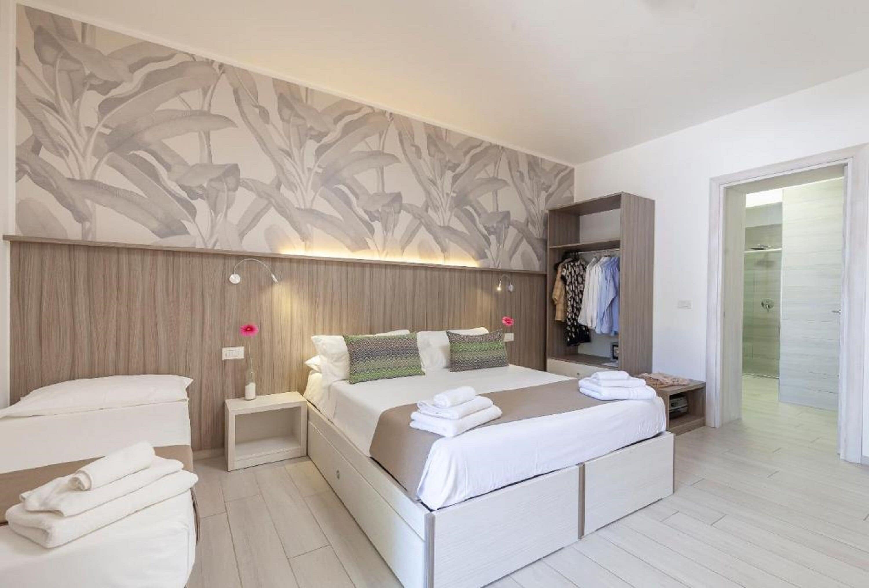 Ein modernes Schlafzimmer mit einem großen Bett, einem Nachttisch, einem Kleiderschrank und einer Duschkabine.