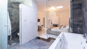 Ein modernes Badezimmer mit Duschkabine aus Glas, einem großen Spiegel und einer freistehenden Badewanne.