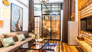 Una sala de estar moderna con un sofá, una mesa de centro y un ventanal con cortinas.